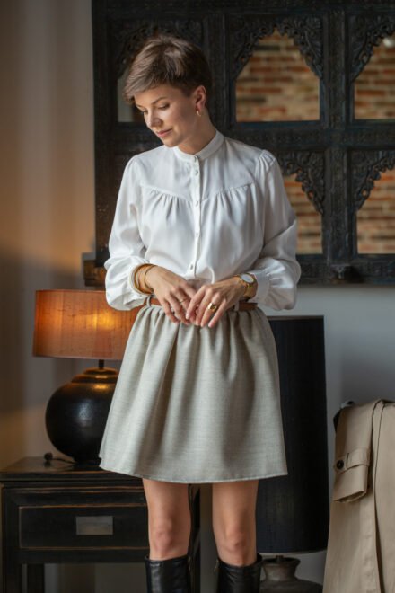 eleganckie ubrania do pracy: wełniana krótka spódniczka damska z wełny merino naturalna jodełka z elegancką wizytową lejącą koszulą w kolorze śmietankowym szytą z tencelu polska marka